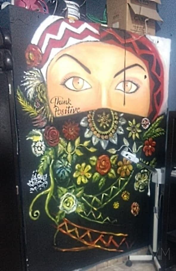 Mujer con velo floral y mensaje Think Positive, pintura sobre fondo oscuro llena de color.