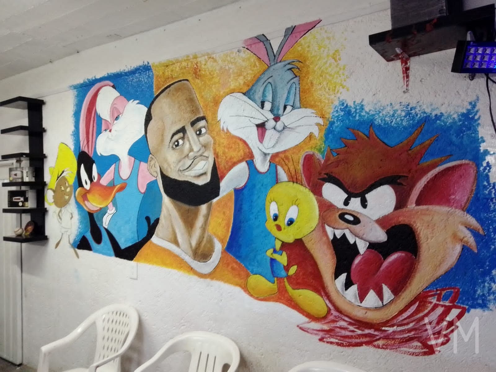 Mural con los personajes de Looney Tunes junto a un jugador de basketball, estilo Space Jam.